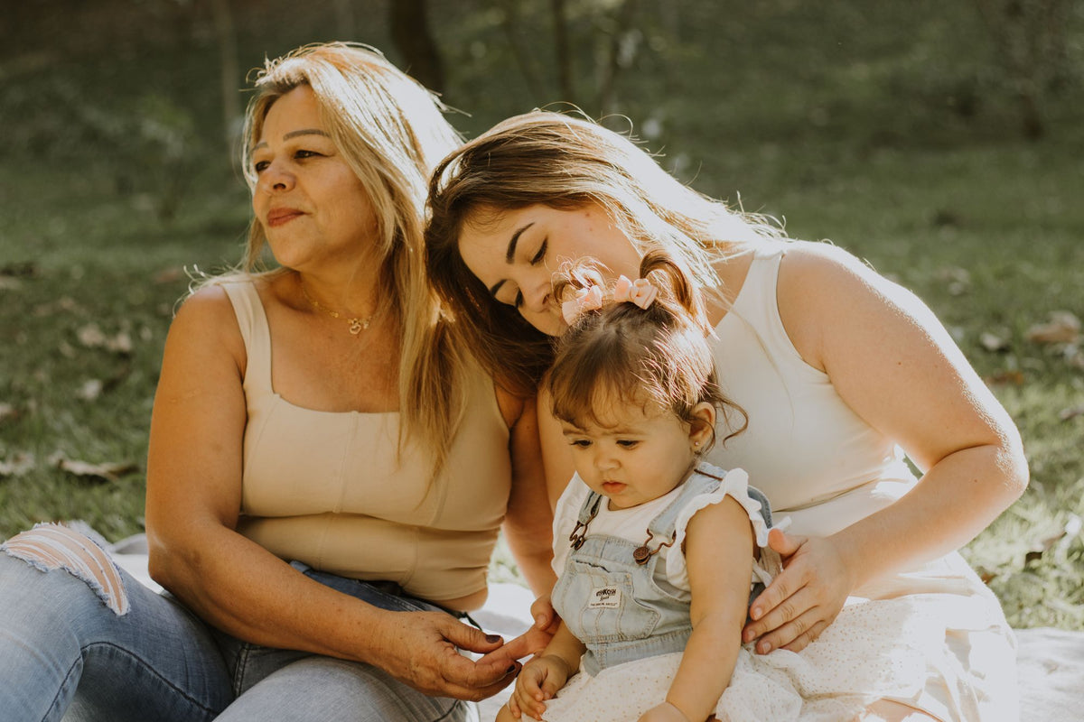 Grandmother, mother and little girl cuddled together in warm sunlight