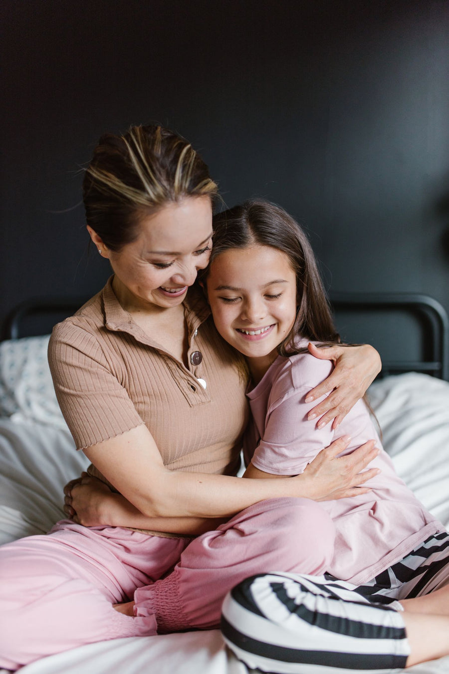 A mother and daughter hugging and smiling